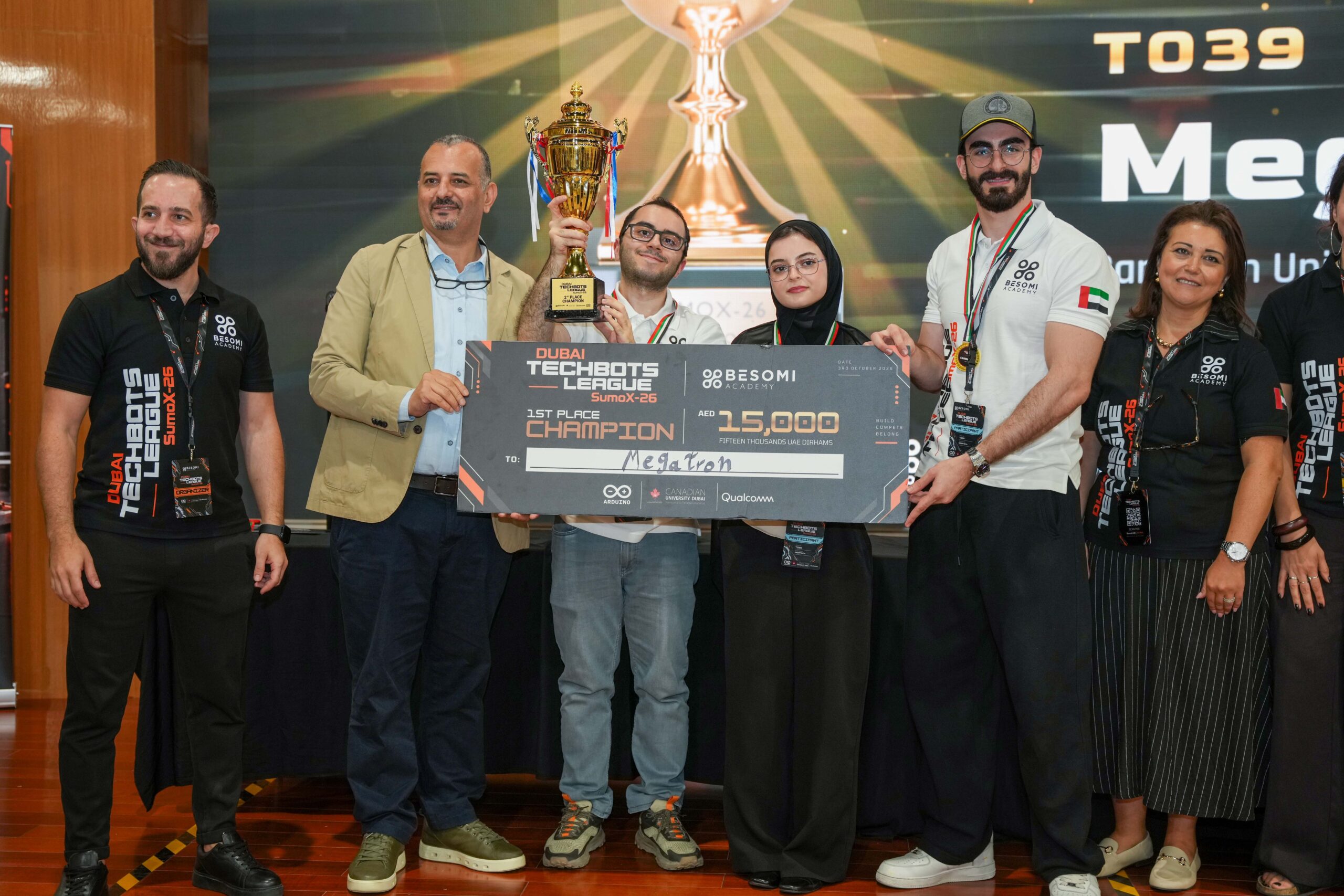 Read more about the article طلاب الهندسة في الجامعة الكندية دبي يحققون إنجازاً تاريخياً بفوزهم  دون أي هزيمة في اختتام بطولة “SumoX 26” ضمن دوري “دبي تيك بوتس”     حقق طلاب الهندسة في الجامعة الكندية دبي  إنجازاً تاريخياً بفوزهم باللقب الوطني على مستوى دولة الإمارات في بطولة “SumoX 26” ضمن دوري “دبي تيك بوتس”، حيث أنهوا المنافسة بسجل خالٍ من الهزائم في مواجهة فرق مثلت 13 جامعة من مختلف أنحاء البلاد. برز الفريق الفائز من الجامعة الكندية دبي  الذي ضم كلاً من أنتوني إبراهيم، ومايا صلاحي الأصبحي، وهادي المبارك- بصفته بطل المسابقة على المستوى الوطني ودون أي هزيمة، متفوقاً بذلك على 46 فريقاً و131 طالباً من جامعات مختلفة في جميع أنحاء دولة الإمارات العربية المتحدة. وقد نجح الطلاب -بفضل التوجيه والإرشاد المتميزين- في الجمع بين الدقة التقنية والهدوء والثبات الانفعالي، والقدرة على اتخاذ قرارات استراتيجية، وروح العمل الجماعي الاستثنائي، ليقدموا أداءً لافتاً ومتميزاً بدءاً من الجولات الافتتاحية ووصولاً إلى المباراة النهائية. استضافت الجامعة الكندية دبي، بدعم من مجموعة بسومي وأردوينو وكوالكوم، مسابقة دبي تيك بوتس ليغ سوموكس 26، التي جمعت المواهب الهندسية الصاعدة من جميع أنحاء الإمارات العربية المتحدة لخوض تحدٍّ في مجال الروبوتات المستقلة، تطلّب أكثر بكثير من مجرد المعرفة التقنية. إذ كان على الفرق تصميم وبناء وبرمجة روبوتات قادرة على اتخاذ قرارات سريعة وذكية في بيئة تنافسية. تم تصميم الروبوت الفائز لفريق الجامعة الكندية دبي وبنائه كمشروع هندسي عملي يجمع بين التصميم الميكانيكي والإلكتروني والاستشعار الذكي والبرمجة المدمجة. يبلغ وزنه ثلاثة كيلوغرامات ويعمل بأربعة محركات DC عالية عزم الدوران، وقد تم تصميمه من أجل السرعة والقوة والحركة المستجيبة داخل ساحة السومو التنافسية. استند أداؤه إلى استراتيجية تشغيل ذاتي أُعدت بعناية؛ فقد أتاحت مجموعة من المستشعرات للروبوت تحديد موقع خصمه بسرعة، بينما رصدت مستشعرات الخطوط حافة الحلبة وضمنت بقاءه داخل نطاق المنافسة. ومع بداية كل جولة، كان الروبوت يمسح محيطه ويحدد الروبوت المنافس، ثم يستجيب بحركات سريعة وموجهة بدقة، محولاً بذلك النظريات الهندسية إلى نتائج حاسمة على أرض الواقع.  يعكس هذا الإنجاز التزام الجامعة الكندية دبي  بإعداد مهندسين قادرين على تحويل الأفكار إلى ابتكارات عملية؛ إذ ينخرط الطلاب -من خلال كلية الهندسة والعلوم التطبيقية والتكنولوجيا- في بيئة تعليمية تستشرف المستقبل، وتجمع بين المعرفة الأكاديمية والتجريب والارتباط بمتطلبات قطاع الصناعة وحل المشكلات بشكل عملي وتطبيقي. من الروبوتات والتشغيل الألي إلى الذكاء الاصطناعي والتقنيات المستدامة والأنظمة الرقمية، يتم تشجيع طلاب الهندسة في الجامعة الكندية دبي على تصميم واختبار وتحسين الحلول للتحديات التي تشكل الصناعة 4.0. وتُعد فرص مثل دوري دبي تيك بوتس سوموكس 26 أساسية لهذا النهج، حيث تُمكّن الطلاب من بناء الثقة التقنية والتعاون عبر التخصصات وإظهار قدراتهم على منصات وطنية هامة.  وقال الدكتور شريف موسى، عميد كلية الهندسة والعلوم التطبيقية والتكنولوجيا في الجامعة الكندية دبي: “يُعد هذا الإنجاز مصدر فخر للجامعة، ودليلاً قوياً على ما يتمتع به طلابنا من مواهب وتفانٍ وطموح تقني. لقد أثبت كل من أنتوني ومايا وهادي ما يمكن تحقيقه عندما يقترن التعلم الأكاديمي بالتطبيق العملي من خلال التحديات الميدانية، والتوجيه من قبل الخبراء، والعمل الجماعي. ويُبرهن فوزهم الوطني -الذي حققوه دون أي هزيمة- على أن طلابنا لا يكتفون بالاستعداد لمستقبل الهندسة فحسب، بل يساهمون بالفعل في تشكيله”. كما تعرب الجامعة الكندية دبي عن خالص الإمتنان والتقدير لمجموعة بسومي، وأكاديمية بسومي، وأردوينو، وكوالكوم، وجميع الشركاء لإنشاء منصة هادفة على مستوى دولة الإمارات العربية المتحدة تمكّن المهندسين الناشئين من اختبار قدراتهم، وتحويل الأفكار إلى ابتكارات، وبناء ما سيأتي بعد ذلك.